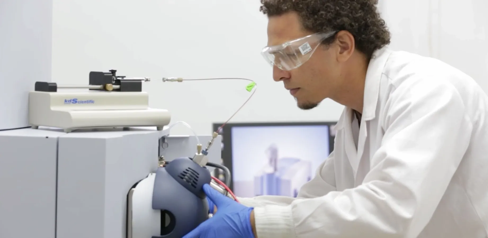 Hombre con indumentaria trabaja en un laboratorio utilizando algunas maquinas